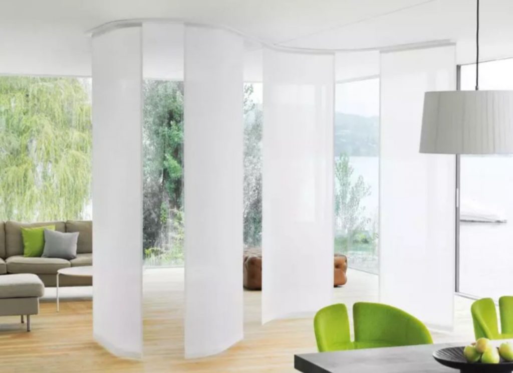 Motorized curtain panels dividing a living room