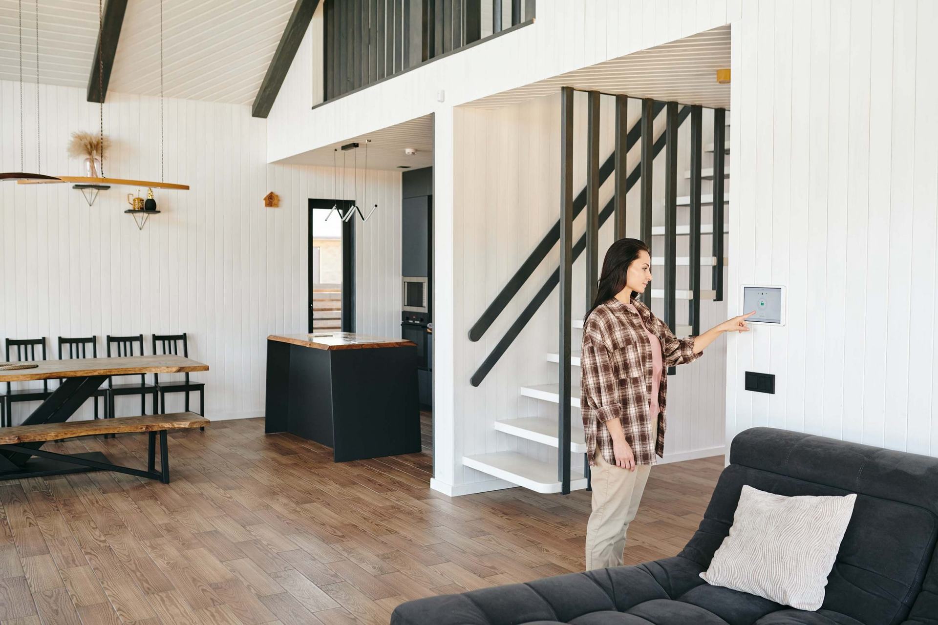 Woman using a KNX wall control panel in a modern home