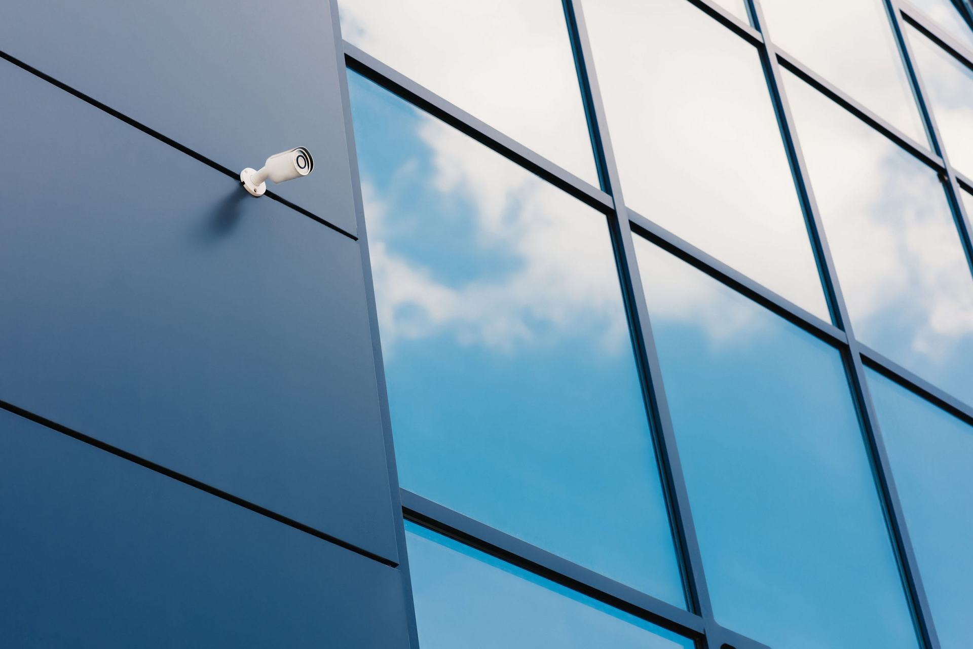 Security camera mounted on a glass office building facade